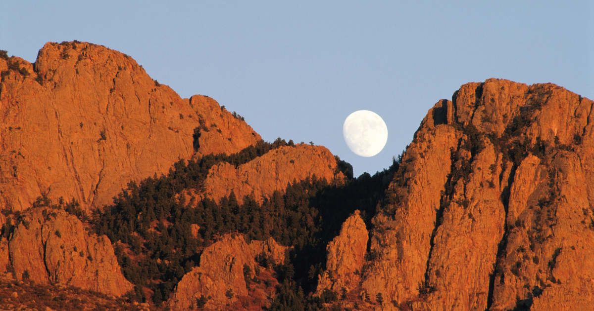 A full moon rising over the Sandia Mountains in Albuquerque, New Mexico, USA. (Cover Image Source: Getty | Ron Crabtree)