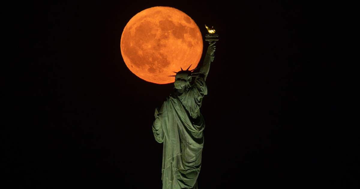 The full Sturgeon Moon rises behind the Statue of Liberty in New York City on August 9, 2025, as seen from Jersey City, New Jersey. (Cover Image Source: Getty | Gary Hershorn)
