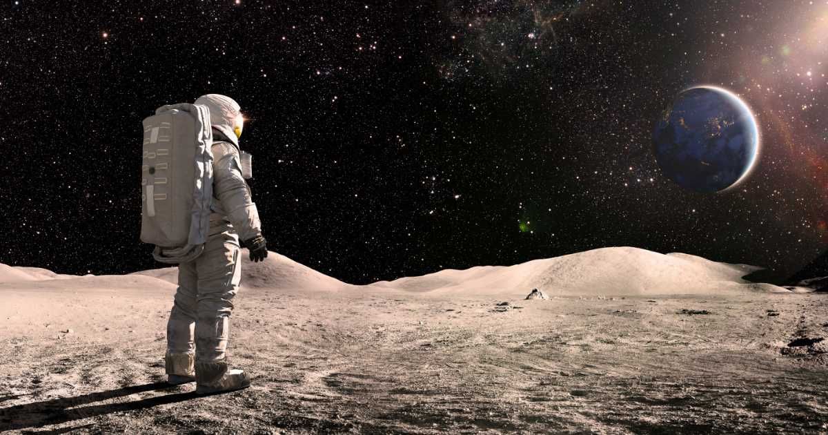 A lone astronaut, standing facing away from the camera dressed in full space suit with backpack, stands still looking towards distant planet Earth.  (Representative Cover Image Source: Getty Images | Photo by peepo) 
