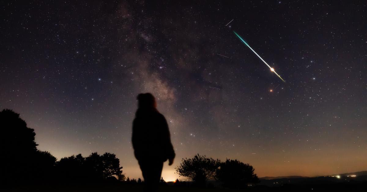 Blurry long exposure silhouette of a person looking at the Milky Way stars with meteor shower trails and countryside night landscape (Representative Cover Image Source: Getty | m-gucci)