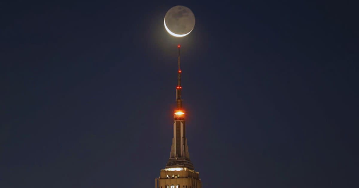 A four percent waning crescent moon illuminated with earthshine rises behind the Empire State Building in New York City. (Representative Cover Image Source: Getty Images | Photo by Gary Hershorn)