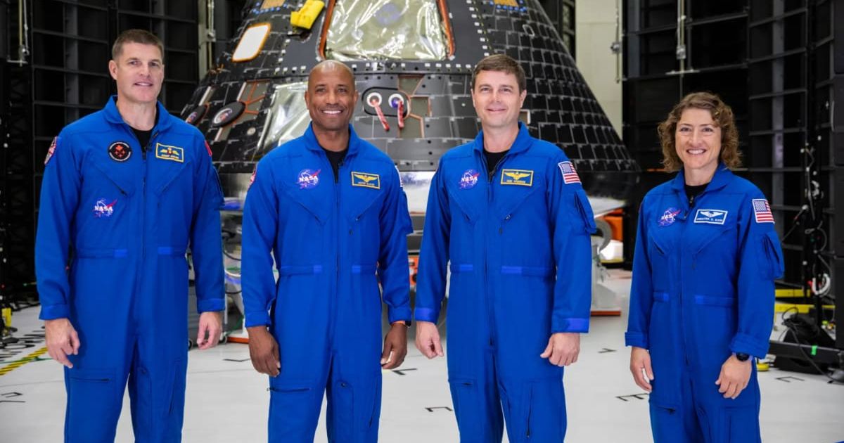 The Artemis II crew is shown inside the Neil Armstrong Operations and Checkout Building at NASA’s Kennedy Space Center in Florida in front of their Orion crew module. (Cover Image Source: NASA | Photo by NASA/Kim Shiflett)