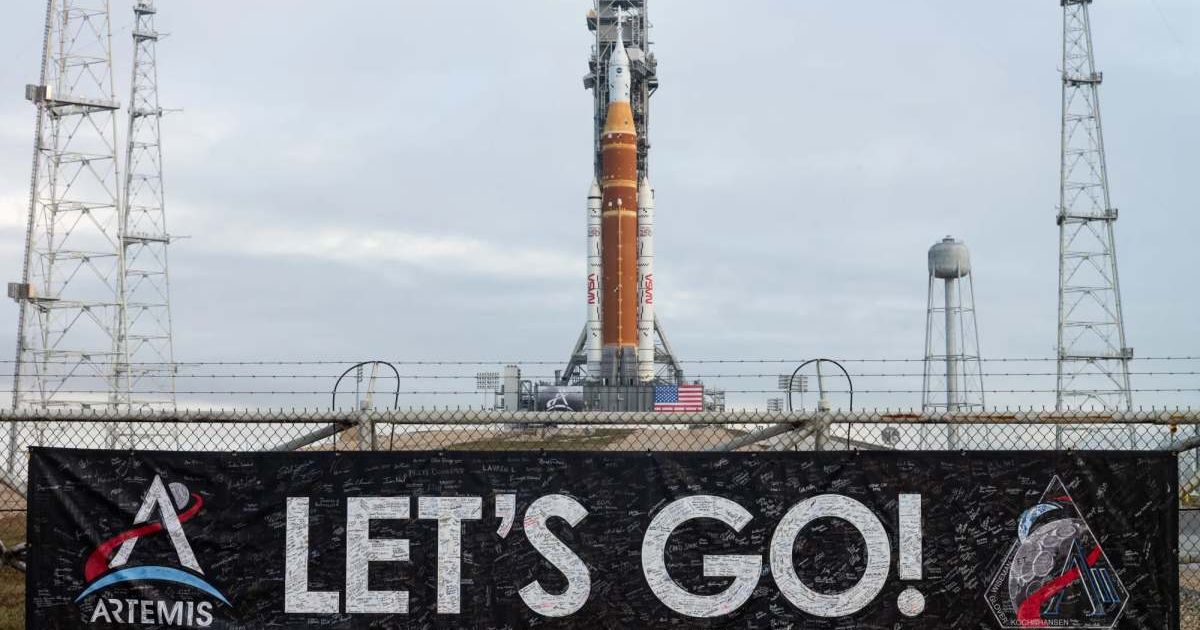A banner covered with the signatures of NASA employees and contractors is seen on the perimeter fence of Launch Complex 39B with NASA’s Artemis II SLS rocket and Orion spacecraft in the background. (Cover Image Source: NASA/Joel Kowsky)