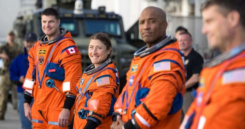 What sets the Artemis II crew's bright orange spacesuit apart from past missions' gear