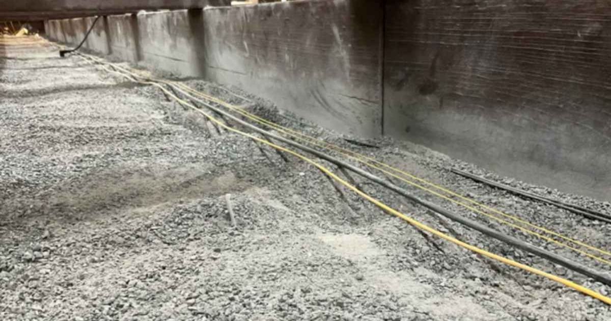 Fiber-optic cables lie on the surface and beneath crushed basalt in an indoor lab at Los Alamos National Laboratory (LANL) to determine whether they could be used on the surface of the moon to detect moonquakes. (Cover Image Source: LANL)