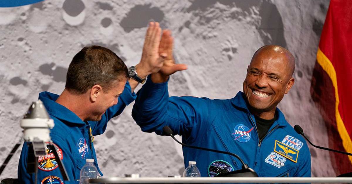Artemis II Commander Reid Wiseman and Pilot Victor Glover high five during the April 16, 2026 news conference at JSC. (Cover Image Source: Danielle Villasana | Getty Images)