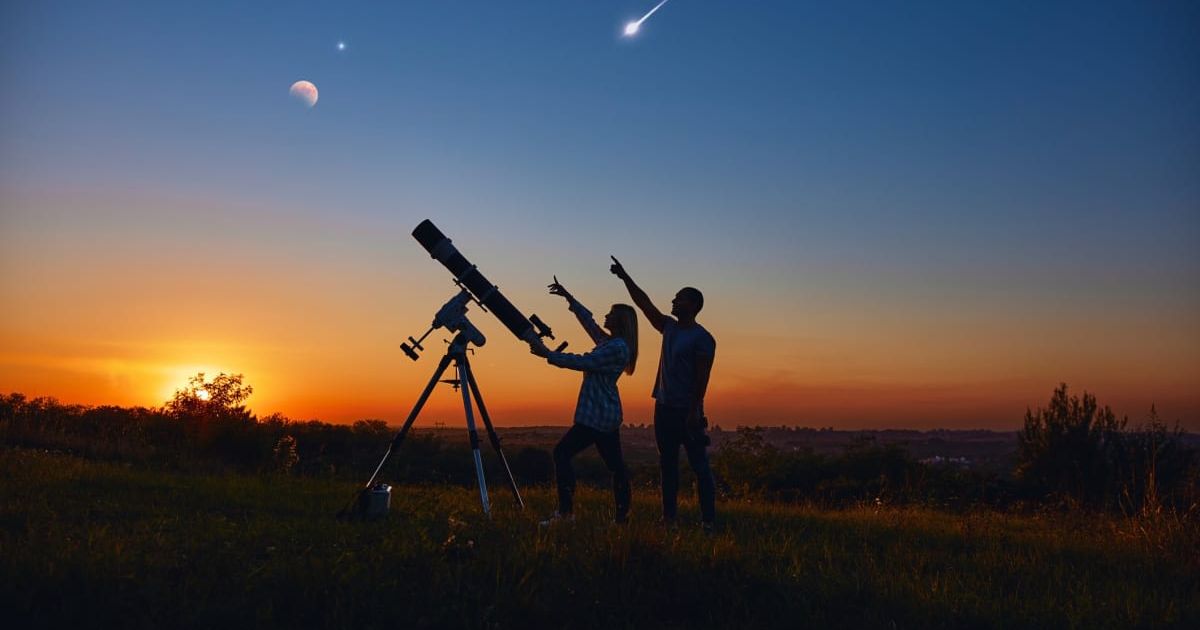Couple stargazing together with a astronomical telescope (Representative Image Source: Getty | m-gucci) 