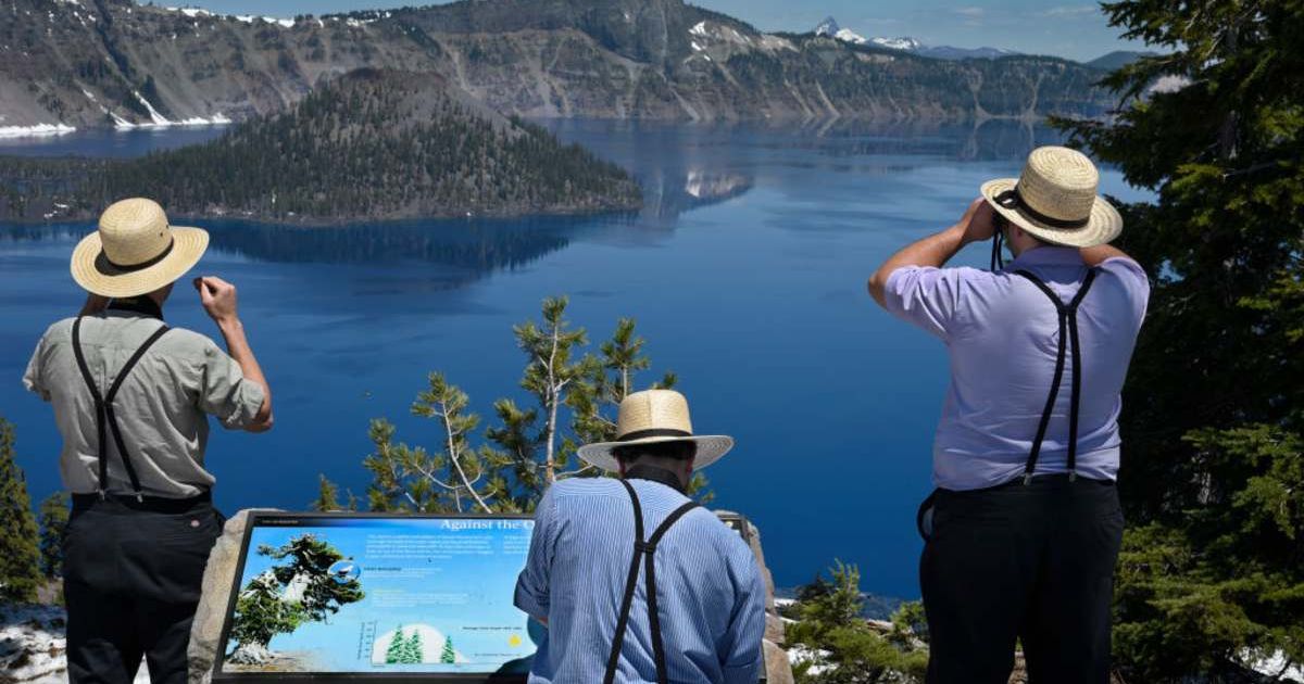 Amish men touring the American West enjoy the view of Crater Lake from a scenic overlook on the lake's rim (Cover Image Source: Getty | Robert Alexander)