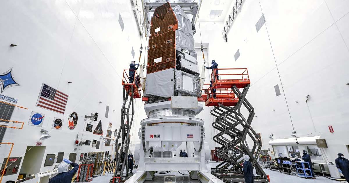 Technicians inside the Payload Hazardous Servicing Facility at NASA’s Kennedy Space Center in Florida use a crane to lift Roman onto a specialized work stand on June 26, 2026. (Image Source: NASA | Sydney Rohde (Rocz))