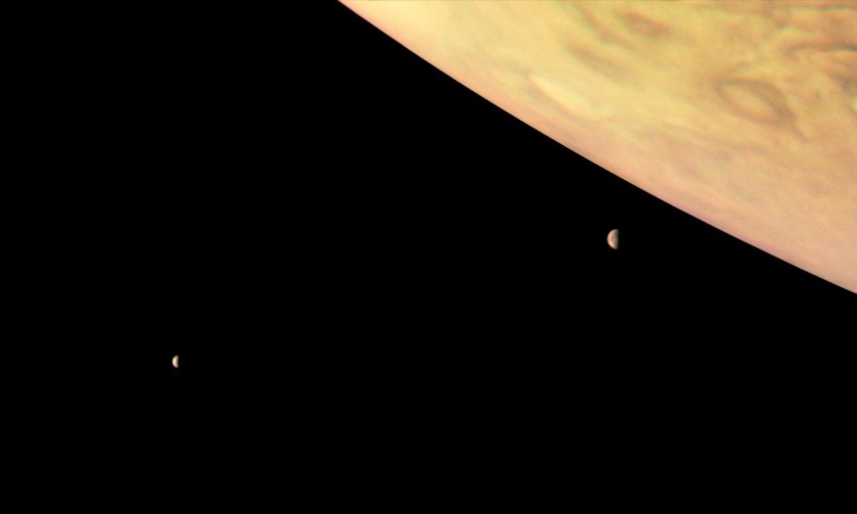 A color-enhanced image of Jupiter and two of its largest moons Io and Europa captured by Juno, Sept. 1, 2017.