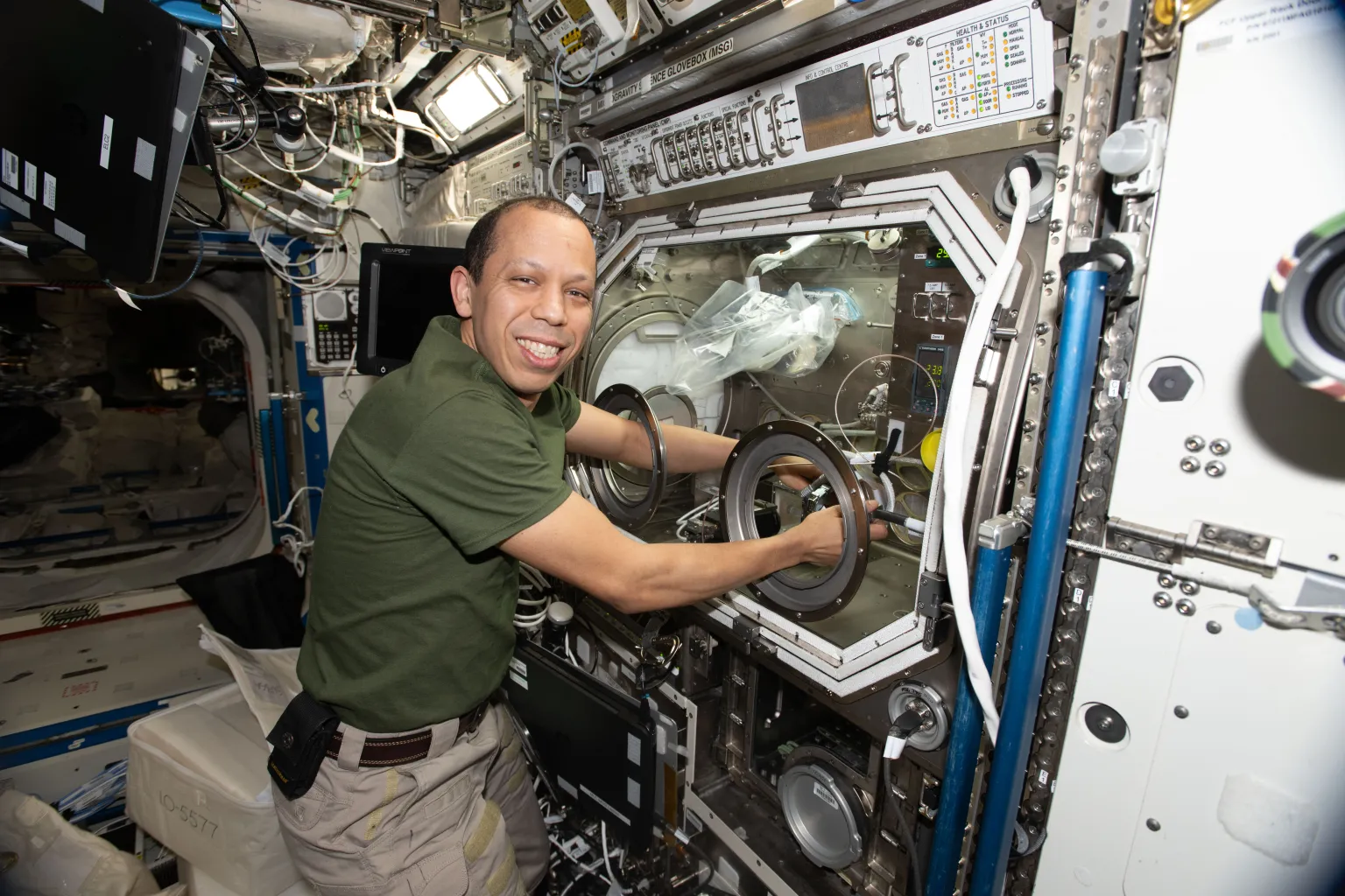 NASA astronaut Chris Williams working with tools to grow semiconductor crystals in space aboard the space station.