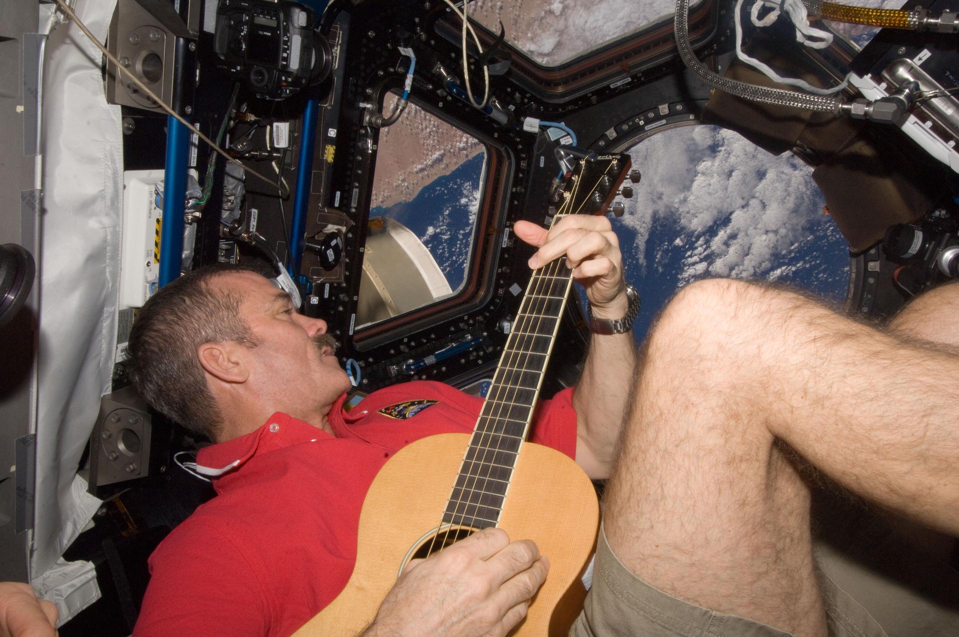 Canadian Space Agency astronaut Chris Hadfield strums his guitar in the International Space Station's Cupola. (Image Source: NASA)