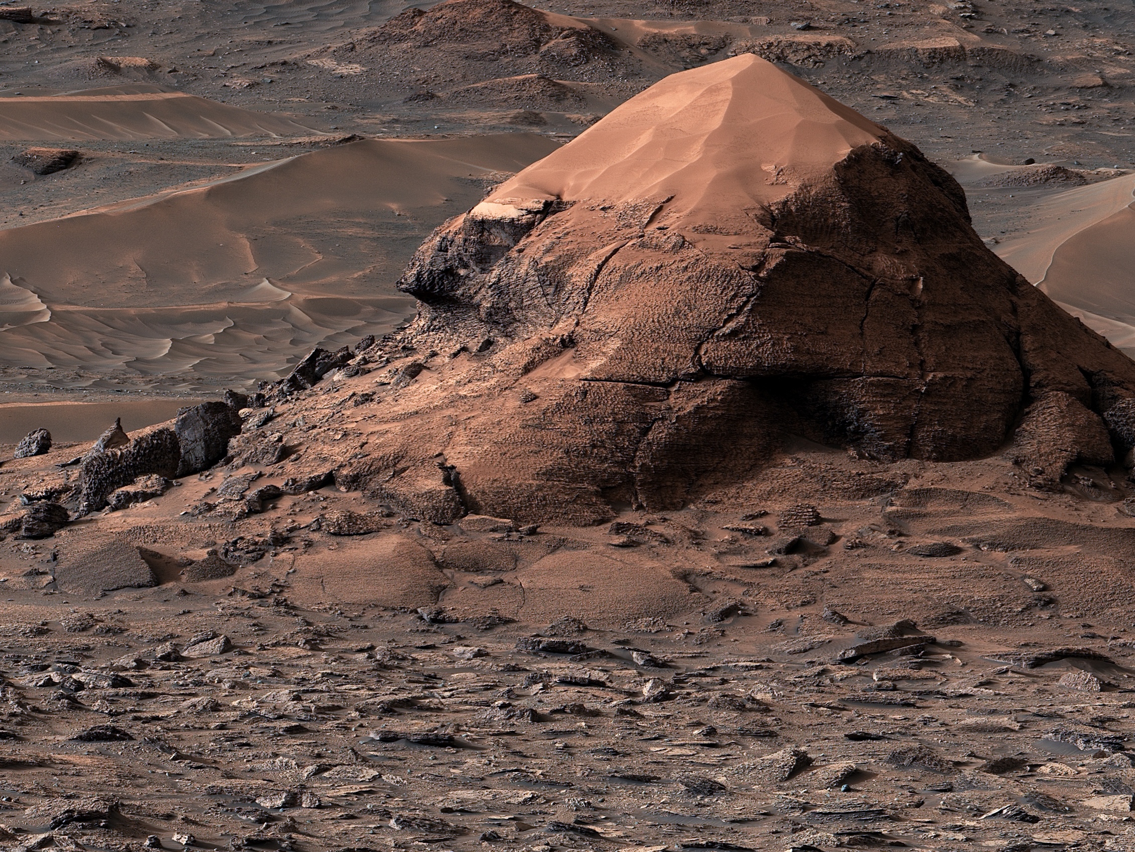 The Miraflores hill photographed by NASA's Curiosity rover in the Gale Crater. Topped with a thick cap of sand, it is also surrounded by the polygonal shapes.
