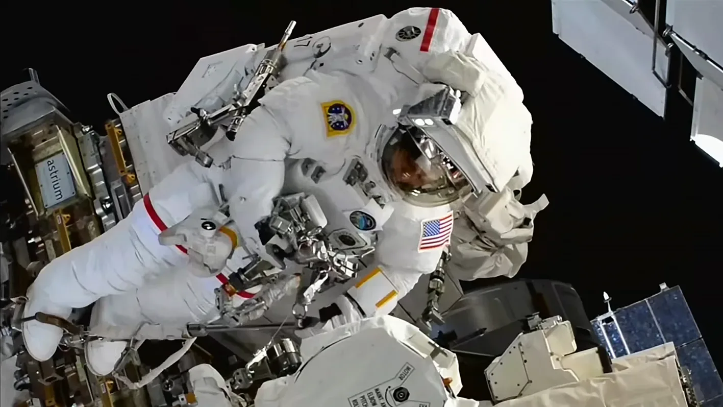 NASA astronaut Chris Williams during a spacewalk outside the International Space Station to swap out a malfunctioning wrist joint on the Canadarm2 robotic arm.