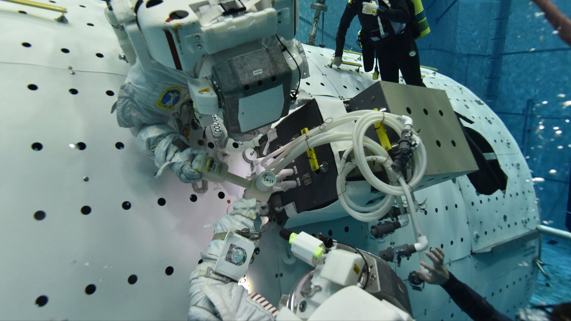 Astronauts training on a mock-up component of the space station at NASA's Neutral Bouyancy Lab at Johnson Space Center.