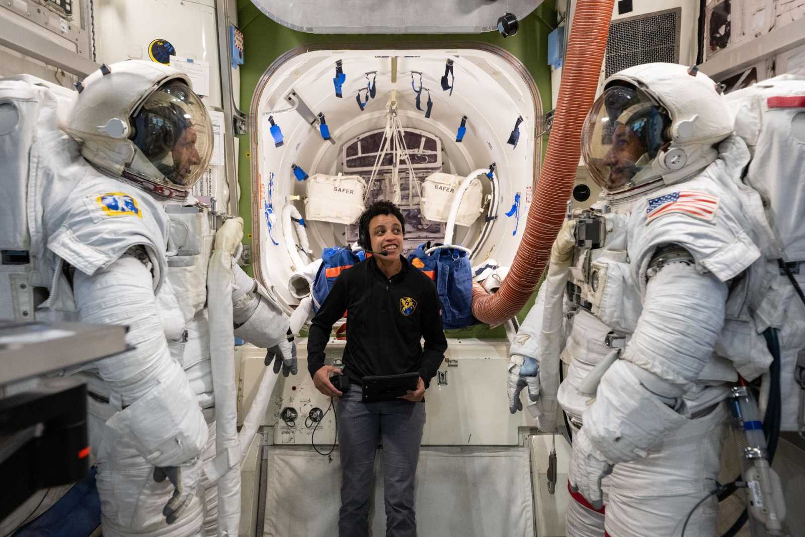 Astronaut Jessica Watkins assists astronauts Josh Kutryk and Luke Delaney as they practice suiting up. (Image Source: NASA/Josh Valcarcel)
