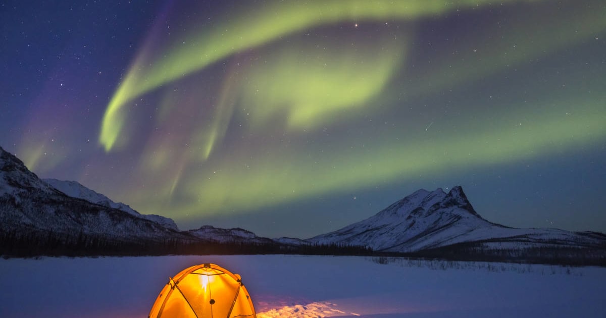 Yellow tent illuminated under the aurora borealis display in Alaska's Arctic. (Representative Image Source: Getty | Patrick J. Endres)