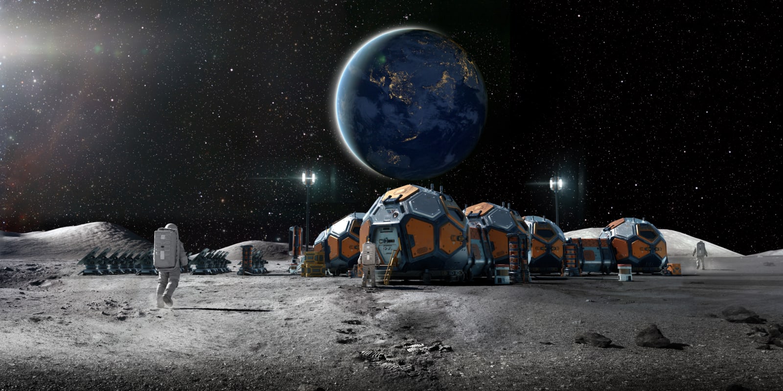 Rear view of an astronaut near some foreground rocks walking towards a lunar base camp made from group of linked habitation pods, solar panels and equipment.