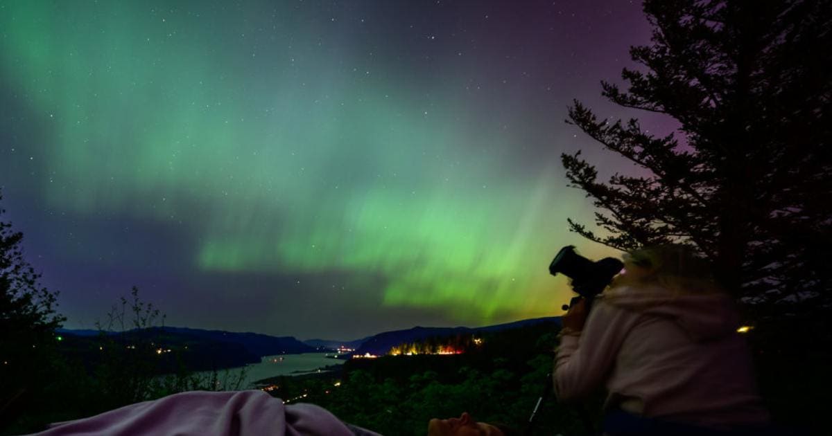 Two women gaze upon the Northern Lights at Chanticleer Point Lookout on the Columbia River Gorge in the early morning hours of May 11, 2024, in Latourell, Oregon (Representative Image Source: Getty | Mathieu Lewis-Rolland)