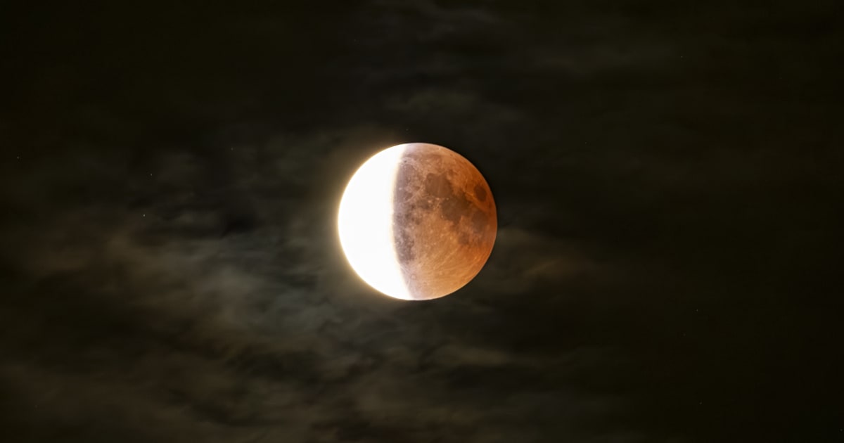A close-up image of a lunar eclipse in a cloudy night — (Cover Image Source: Nicola Colombo/Getty Images)