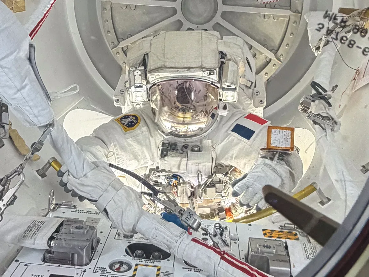 Inside the International Space Station’s Quest airlock, ESA astronaut Sophie Adenot is pictured with her helmet visor down as she nears the end of a six-hour, 23-minute spacewalk on Aug. 18, 2026. (Image Source: NASA/Jack Hathaway)
