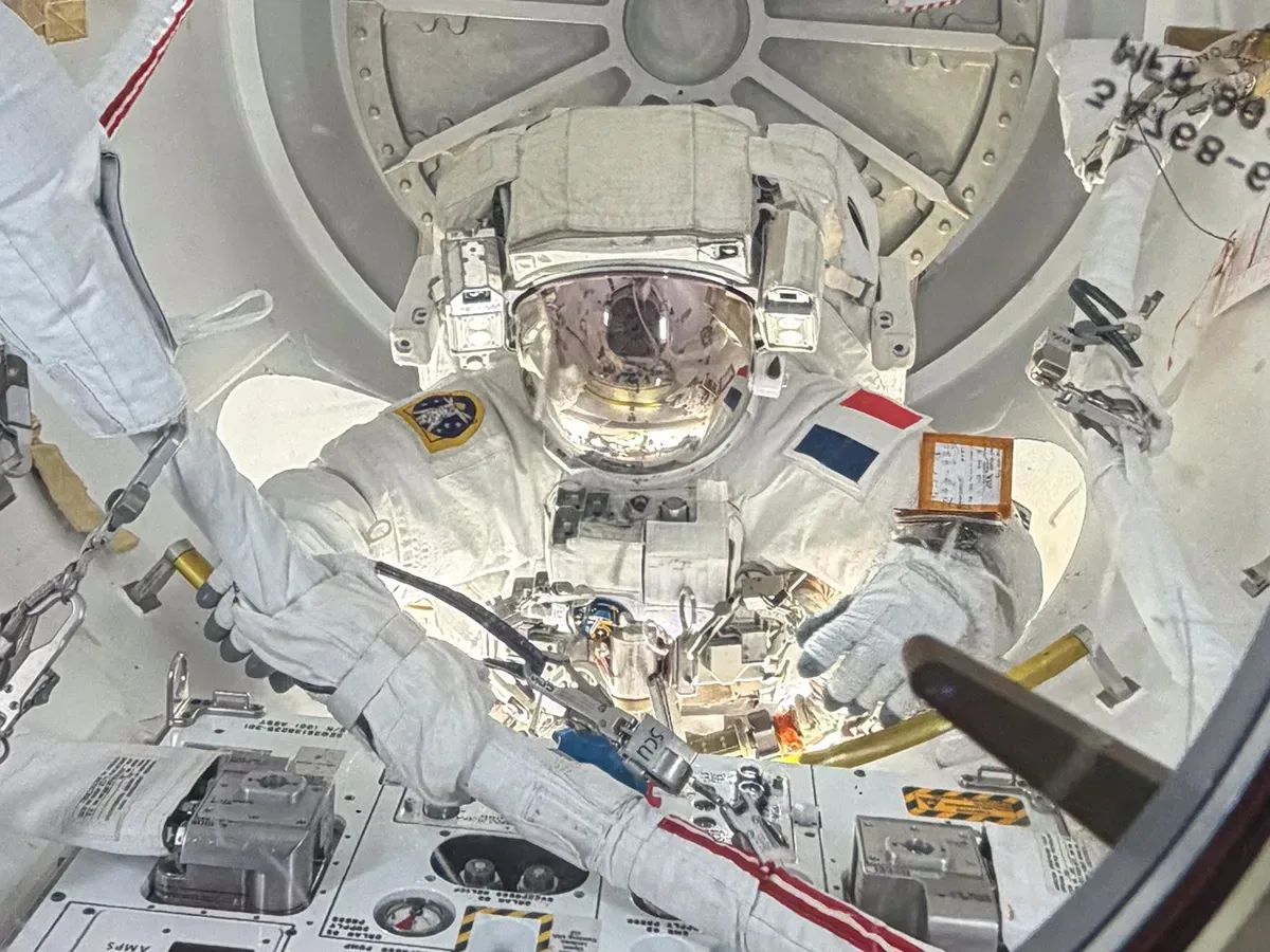 Inside the ISS’s Quest airlock, ESA astronaut Sophie Adenot is pictured with her helmet visor down as she nears the end of a six-hour, 23-minute spacewalk on Aug. 18, 2026