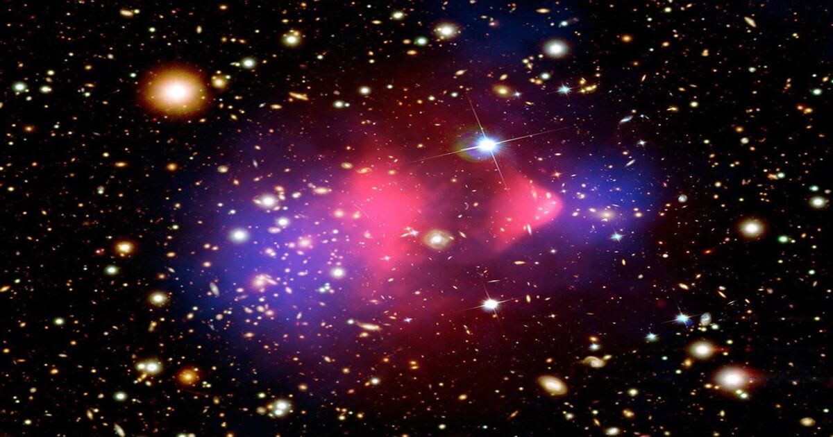 The Bullet Cluster, where two massive galaxy clusters are colliding. The blue areas show the inferred distribution of dark matter. (Image Source: X-ray: NASA/CXC/M. Markevitch et al.; Optical: NASA/STScI; Magellan/U. Arizona/D. Clowe et al.)
