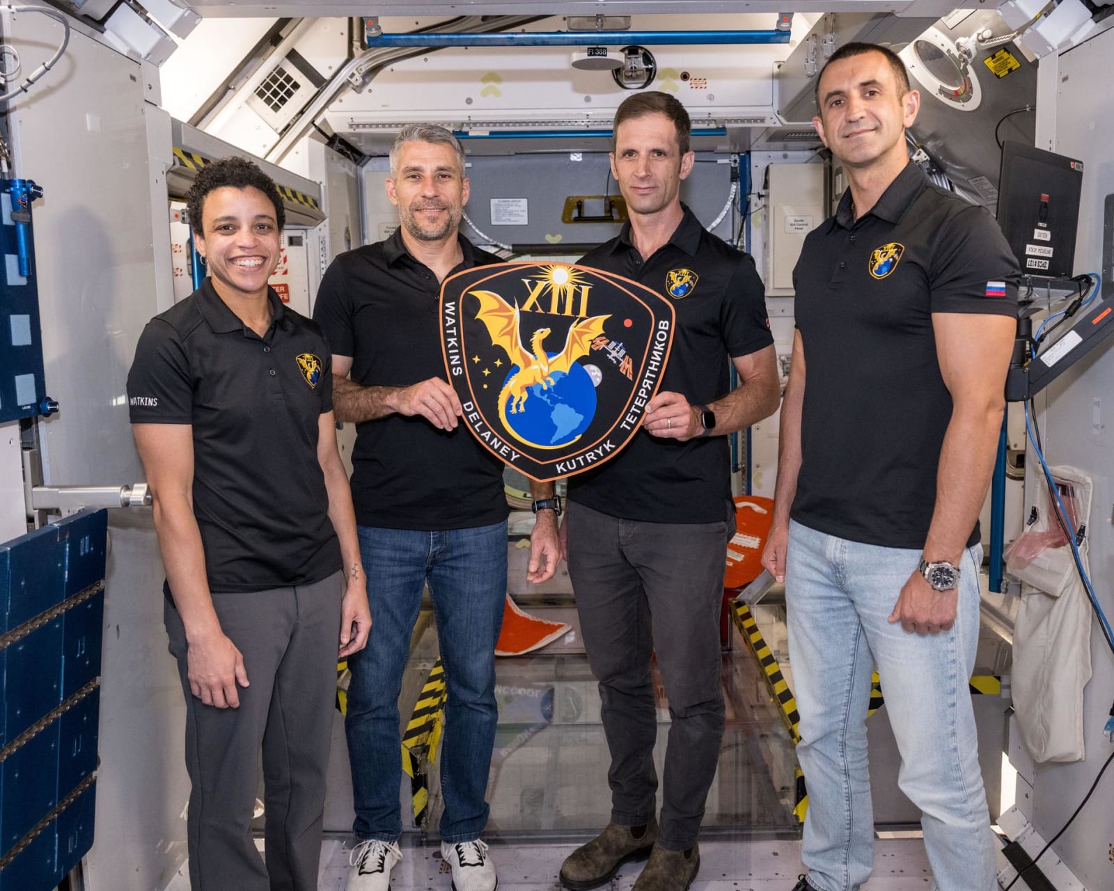 he four members of NASA’s SpaceX Crew-13 mission to the International Space Station display their mission plaque inside a training mockup of a space station module. From left are, Commander Jessica Watkins and Pilot Luke Delaney, both from NASA, and Mission Specialists Joshua Kutryk of CSA (Canadian Space Agency) and Sergey Teteryatnikov of Roscosmos. NASA/Morgan Gridley